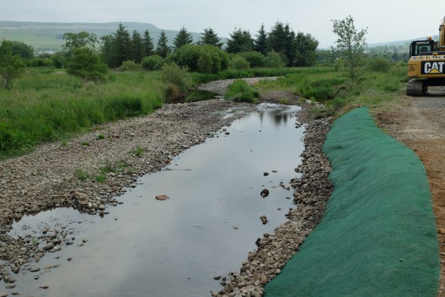 Contractors pinned the geotextile on top of should and 'as dug' rock that was used to rebuild the bank. Hopefully the grass seed will germinate quickly and hold the bank together.